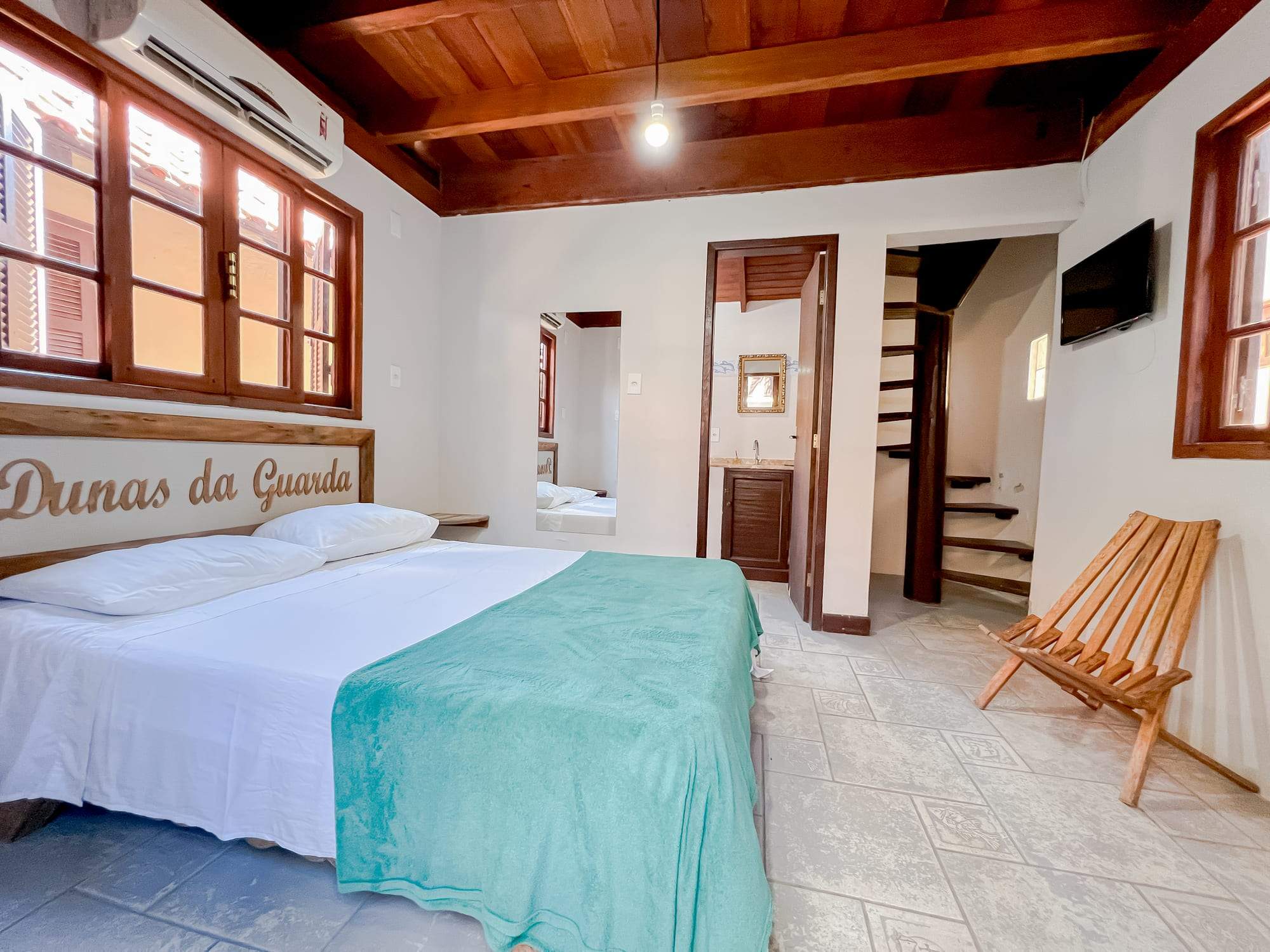 Quarto do conjugado com cama de casal e TV