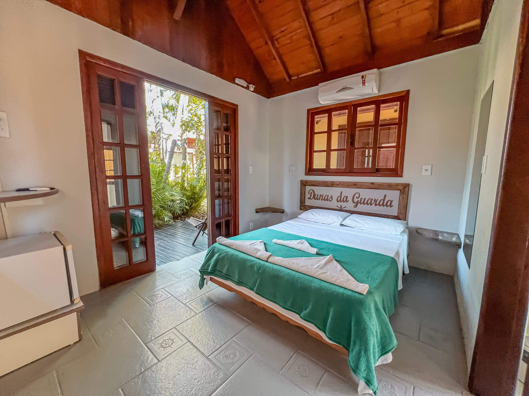 Suíte Rústica com cama de casal e porta para o jardim