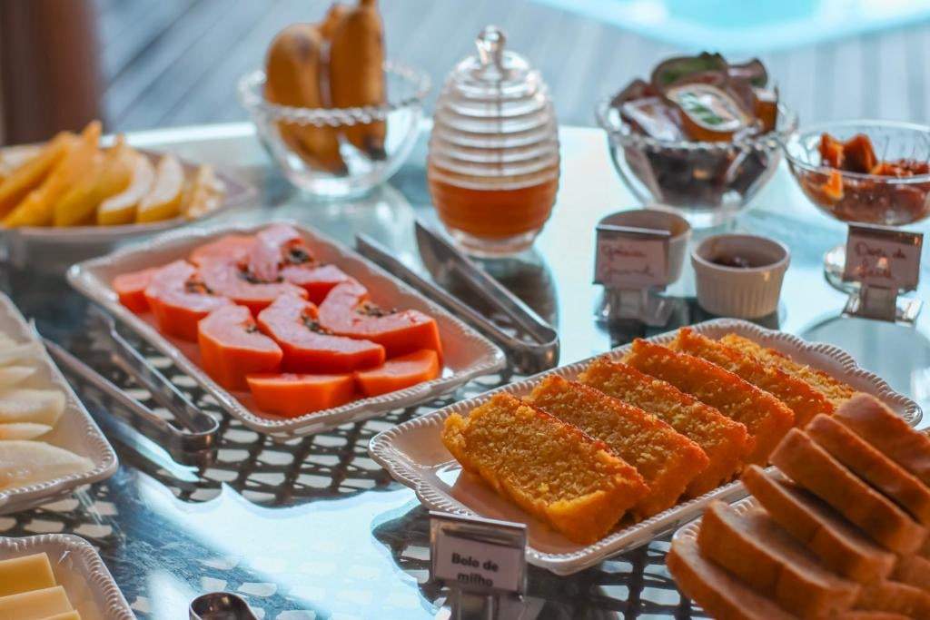 Buffet com mamão, bolos caseiros, mel e geleias