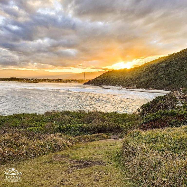 Pôr do sol sobre a praia vista do alto do morro