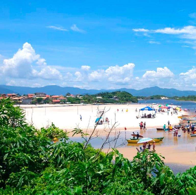 Pessoas atravessando o rio até a faixa de areia da praia